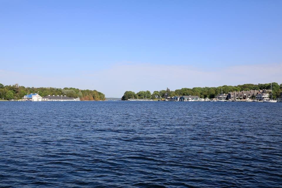 Un lac paisible, avec un quai et des bâtiments situés sur la rive.