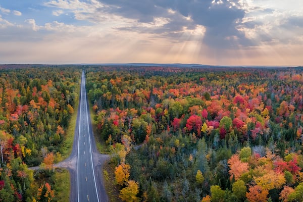 Sunset Autumn drive through the tunnel of Trees in Michigan Upper Peninsula UP - Highway 41 M26 Aerial view