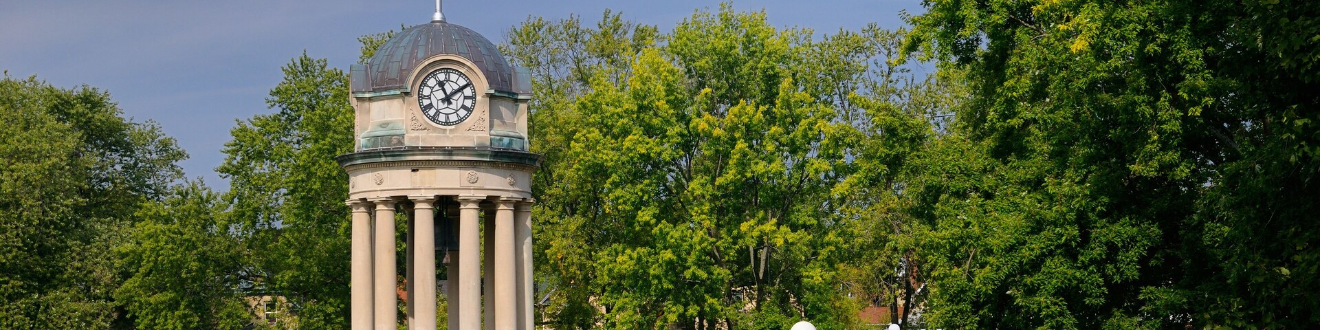 Old City Hall Clock Tower and fountain in Victoria Park Kitchener with Canadian flag