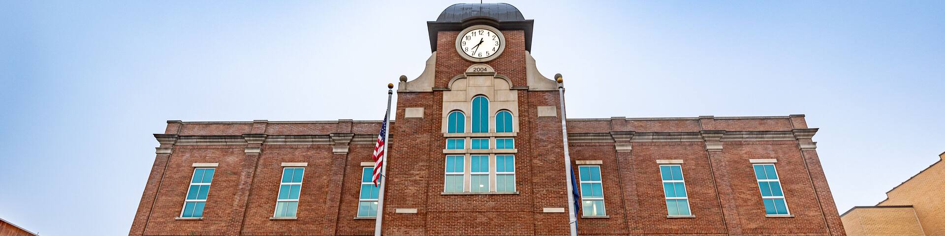 A brick courthouse with a clock tower, a flagpole, and a sign reading "Breathitt County Justice Center".