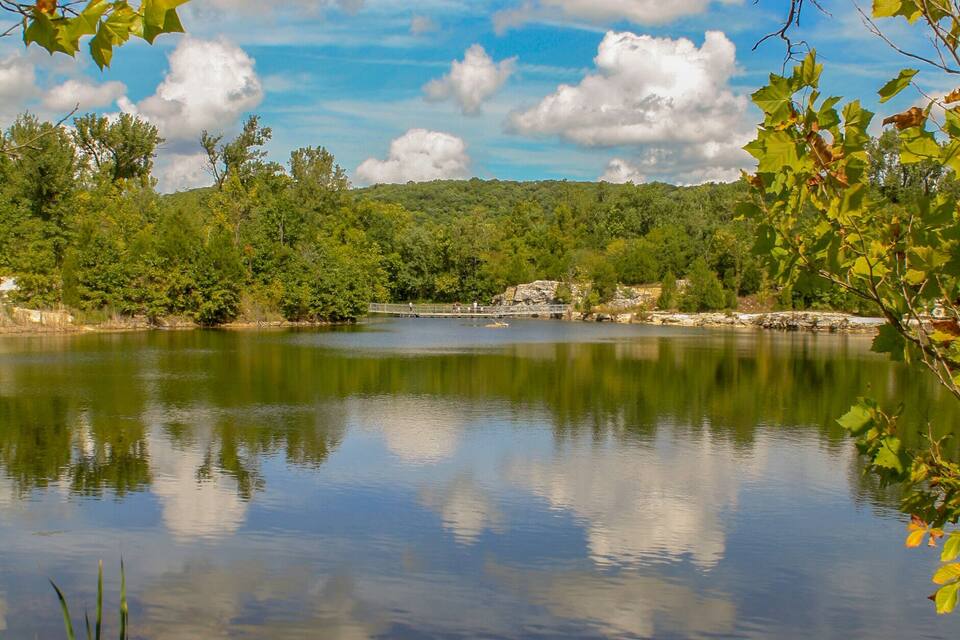 A calm lake surrounded by trees and greenery.