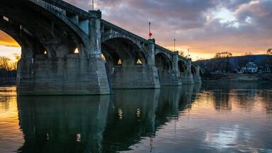 A beautiful sunset behind a bridge over a river in Pittston, PA