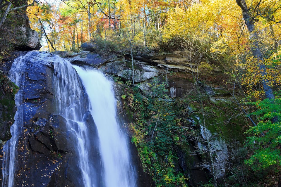A waterfall surrounded by autumn foliage.