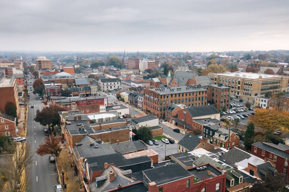 A cityscape with a mix of historic and modern buildings, a prominent church steeple, and a dense urban layout.