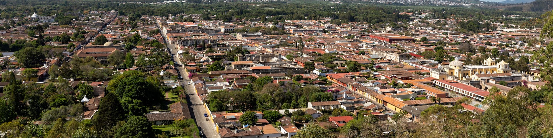 A town with a prominent volcano in the background.