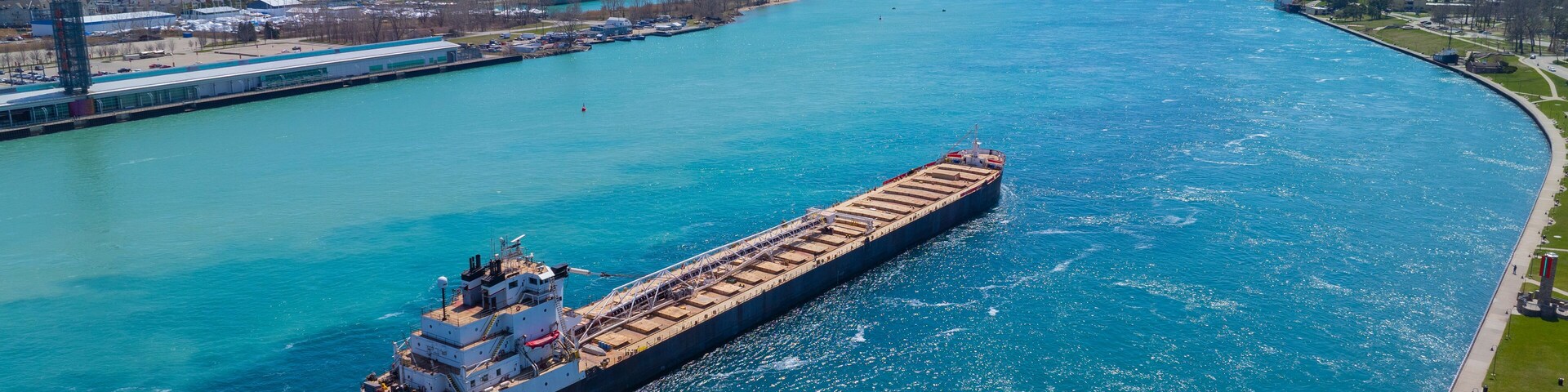 Bulk carrier sailed on St. Clair River aerial view. This river divided Port Huron, Michigan, USA (right) and Point Edward, Ontario, Canada (left).