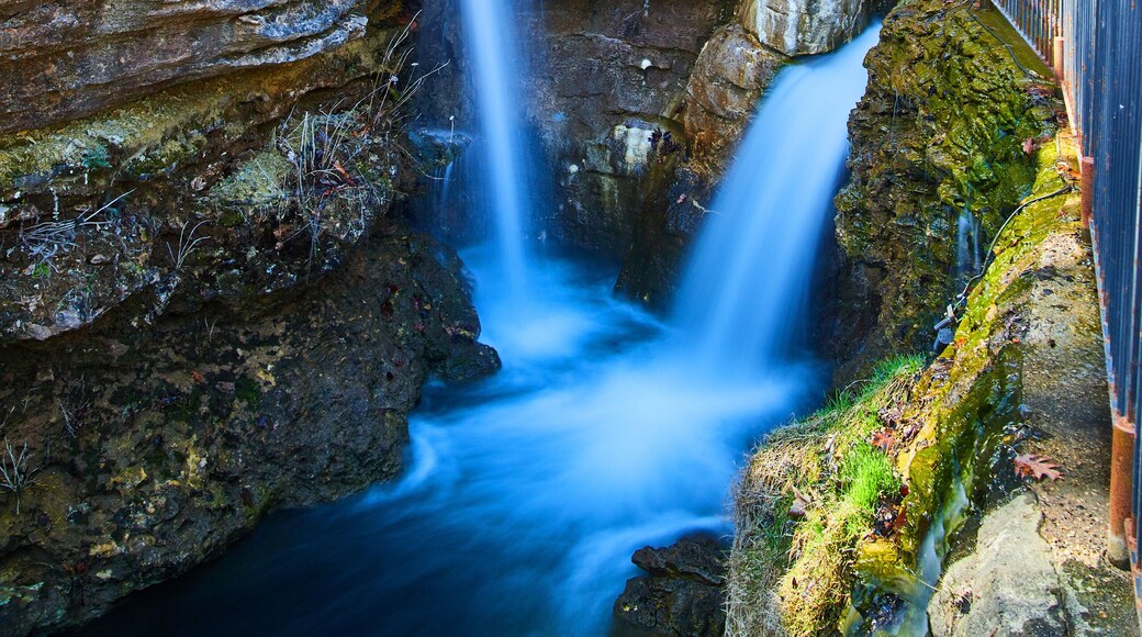 Long exposure of small waterfalls through cliffs next to path