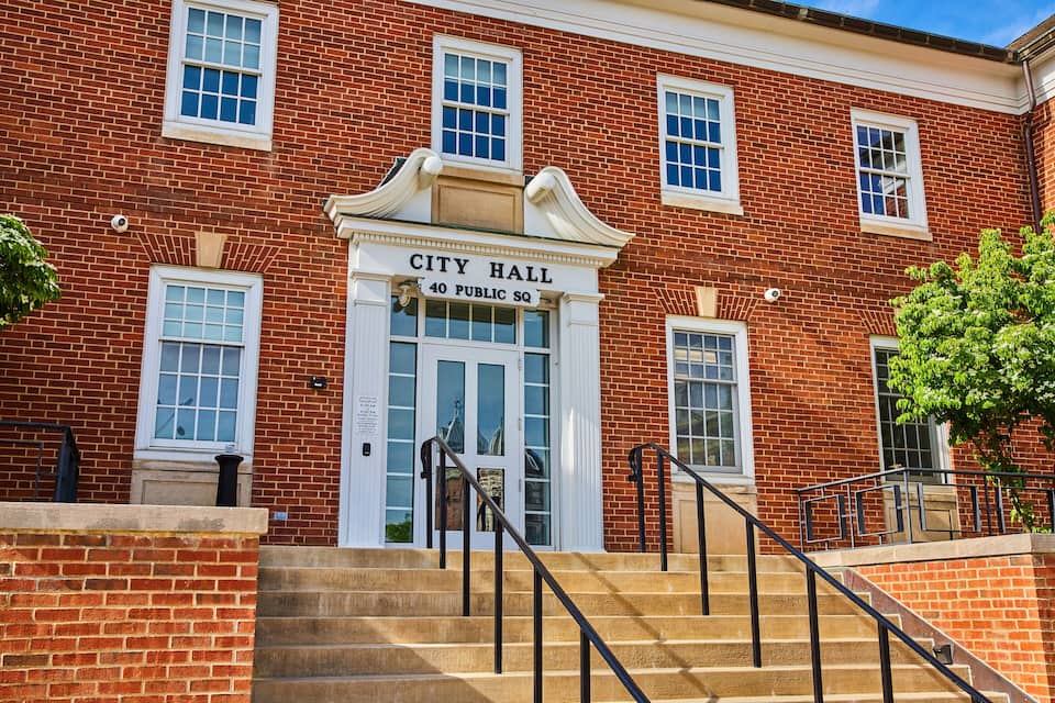 A brick building with a sign reading "City Hall 40 Public Sq."