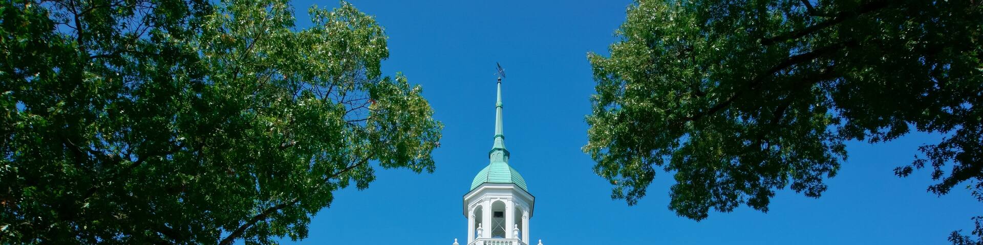 A historic building with a green spire, columns, and the inscription "WESTON TOWN HALL 1917".