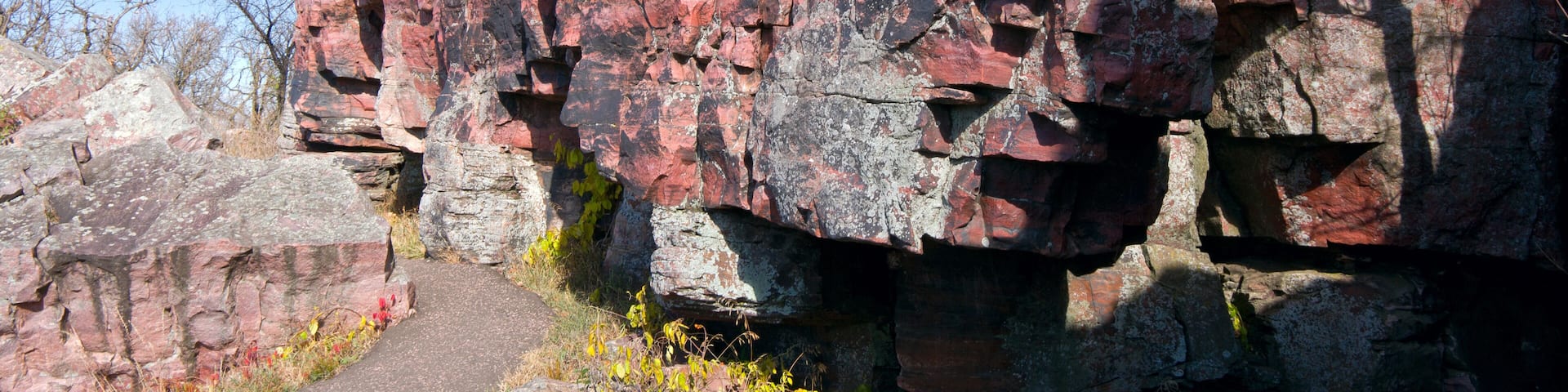 A rocky cliff with a narrow path leading up.
