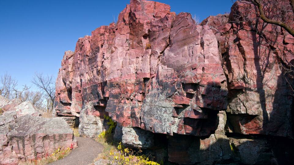 A rocky cliff with a narrow path leading up.