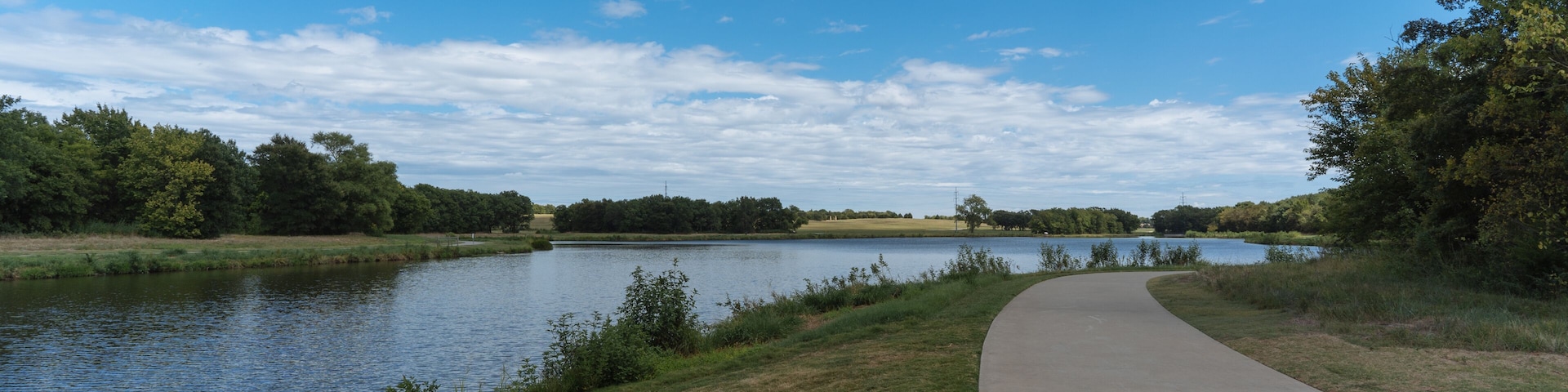 A concrete path in a Texas city park on a sunny August day.
