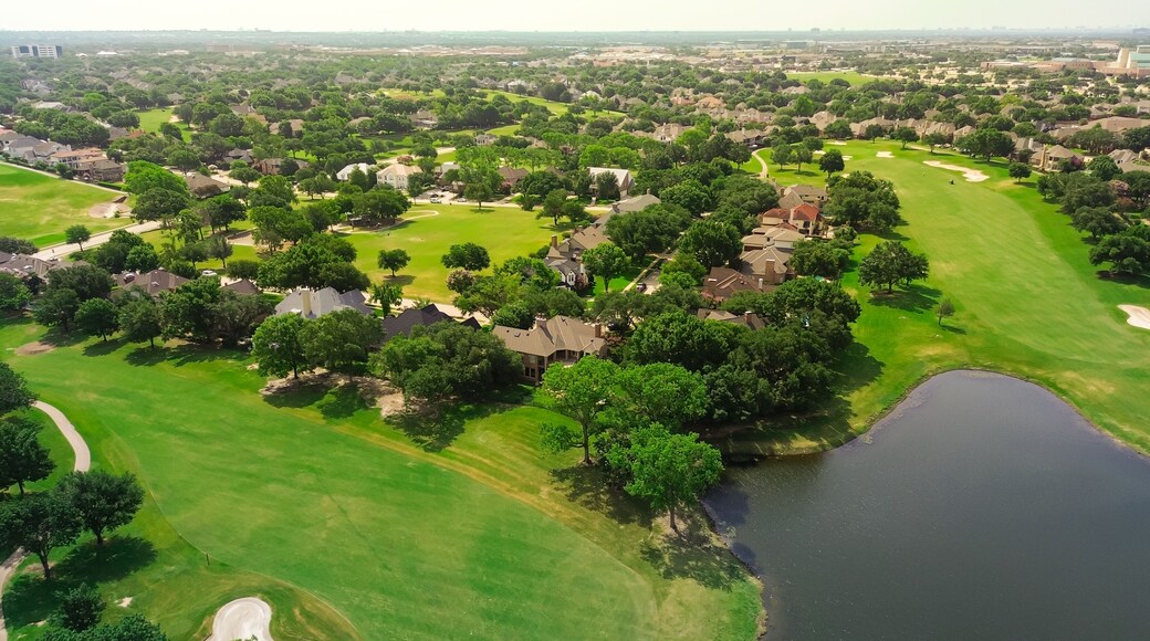Upscale golf community in master planned subdivision urban sprawl, grassy fairway, sand trap bunkers, golfer playing with expensive new development two story mansion houses, Plano Texas, aerial
