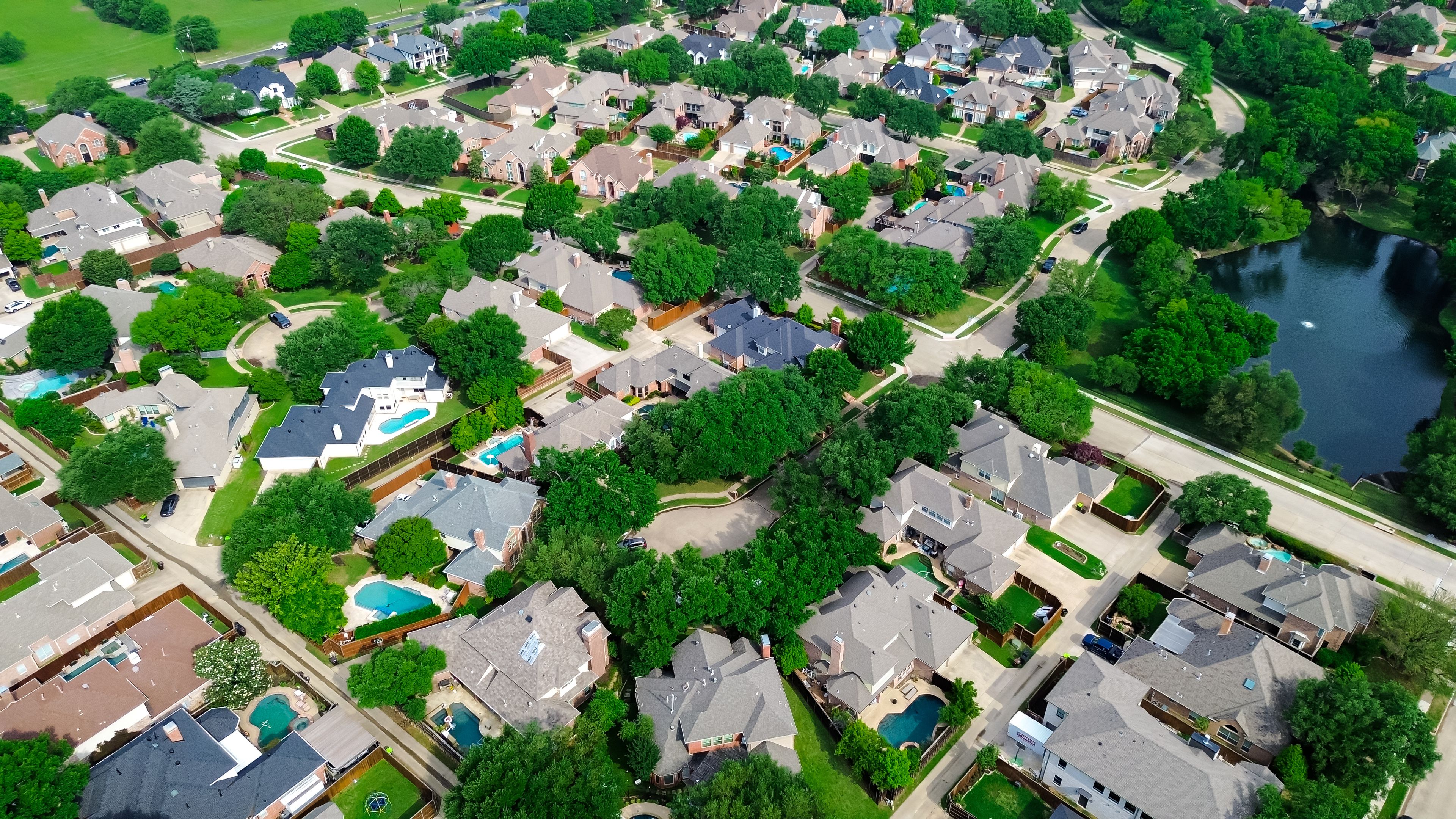 Lakeside mansion homes with solar panel roof, modern inground pools in upscale suburban neighborhood green space near Steeplechase Park and Balcones Drive in Plano, Texas, suburbs Dallas, aerial