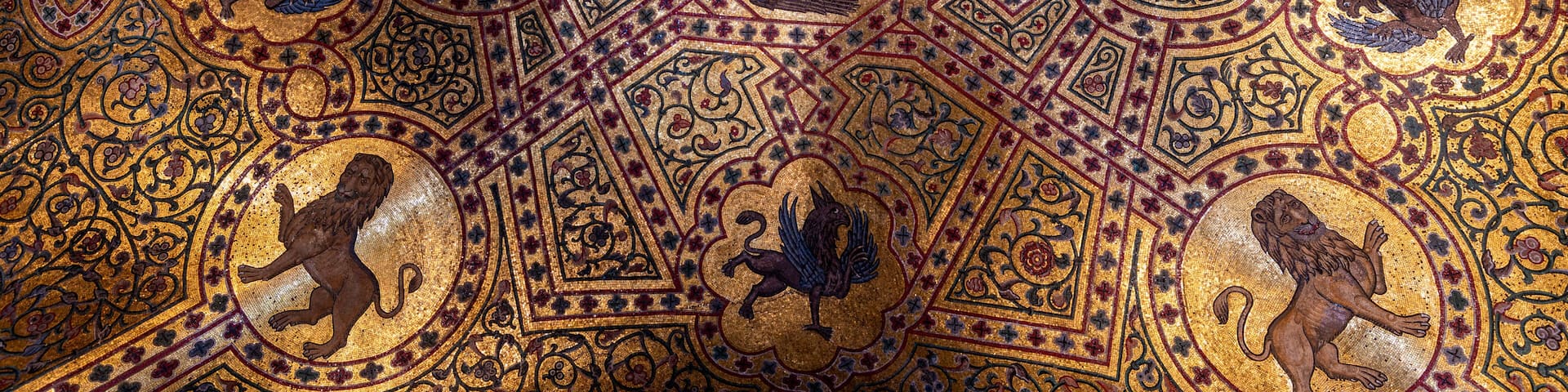 A detailed mosaic ceiling with geometric patterns and animal figures.