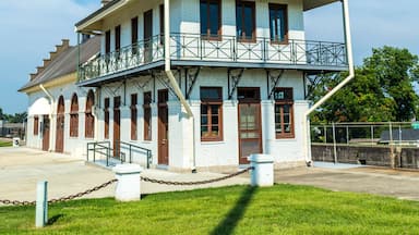 Een historisch gebouw met een witte gevel, blauwe accenten en een balkon.