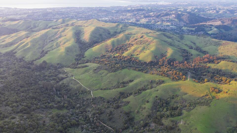 A hilly landscape with a winding road and a distant town.