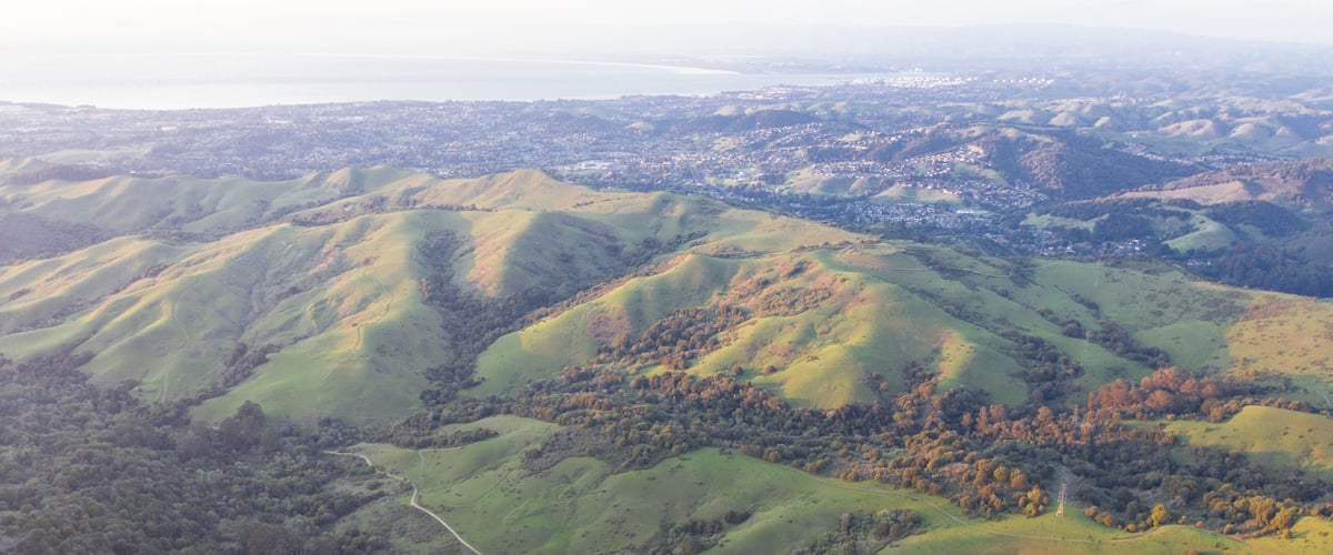 Evening sunlight shines on the green hills of the East Bay in Northern California. This open area, east of San Francisco Bay, is green in the winter due to rain and golden during the summer.