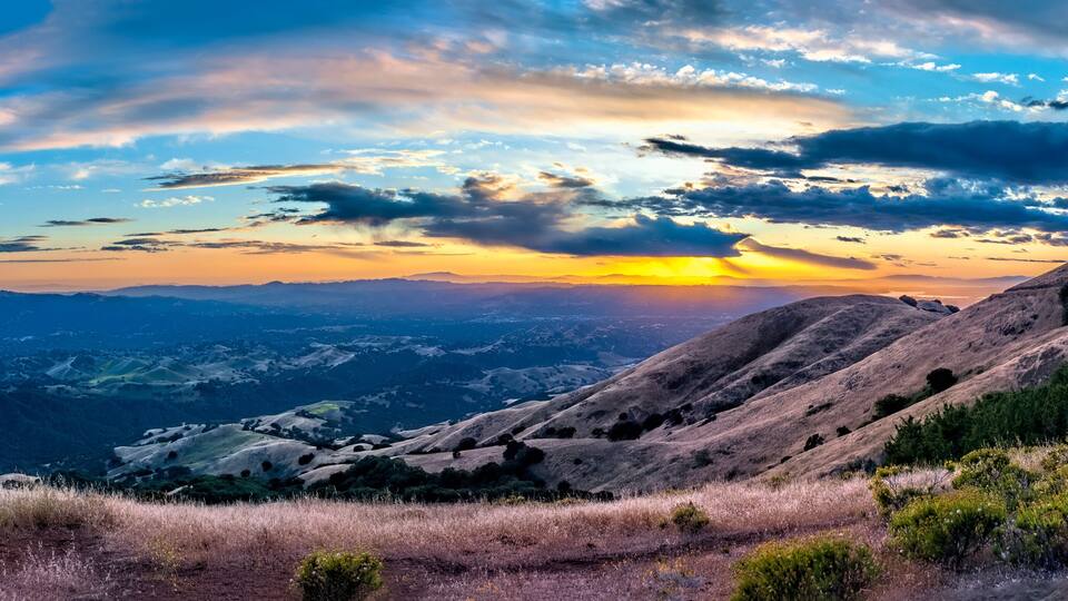 A mountainous landscape with a sunset.