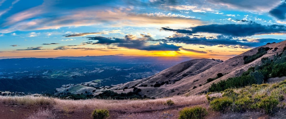 A mountainous landscape with a sunset.