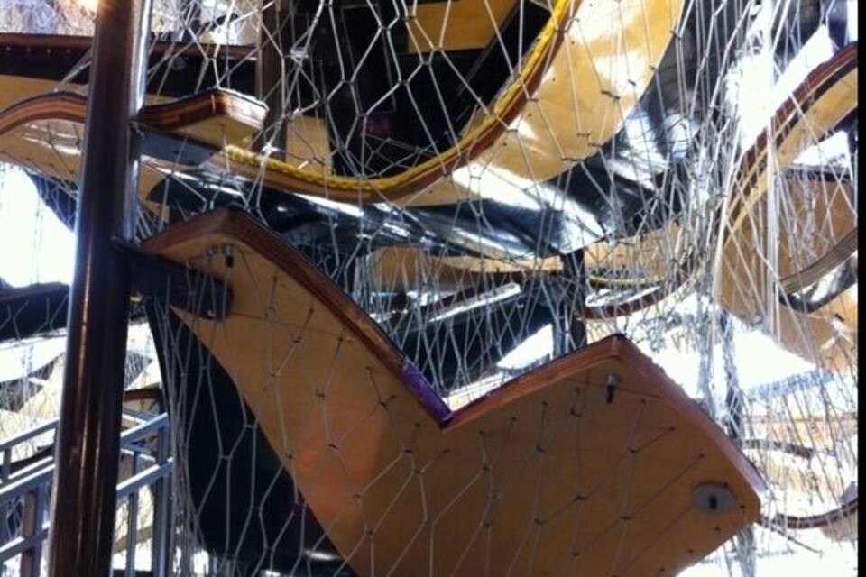 A damaged amusement park ride with yellow seats and a metal frame.