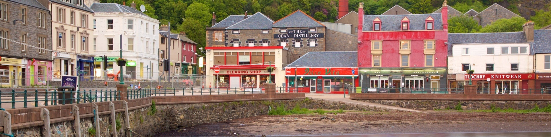 A riverside town with historic buildings, including a distillery and a clearing shop.