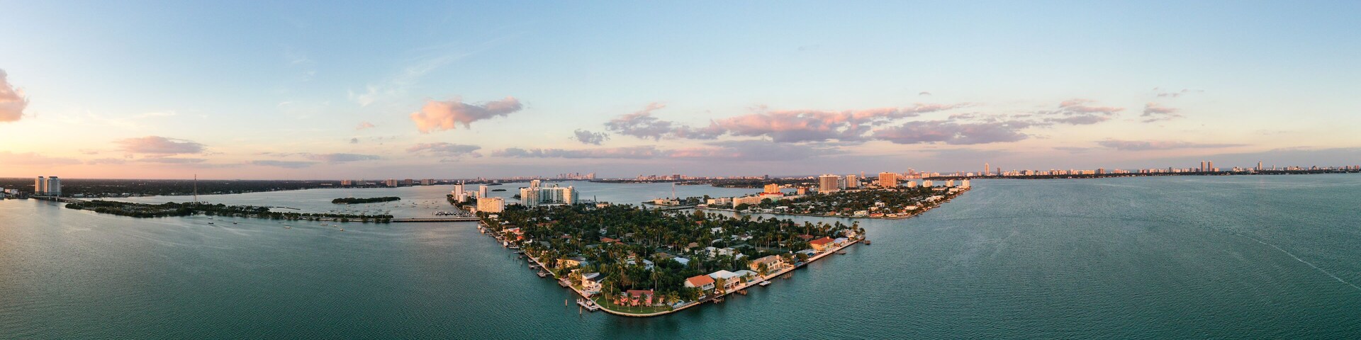 A coastal cityscape with a prominent peninsula featuring residential and commercial buildings, surrounded by water.