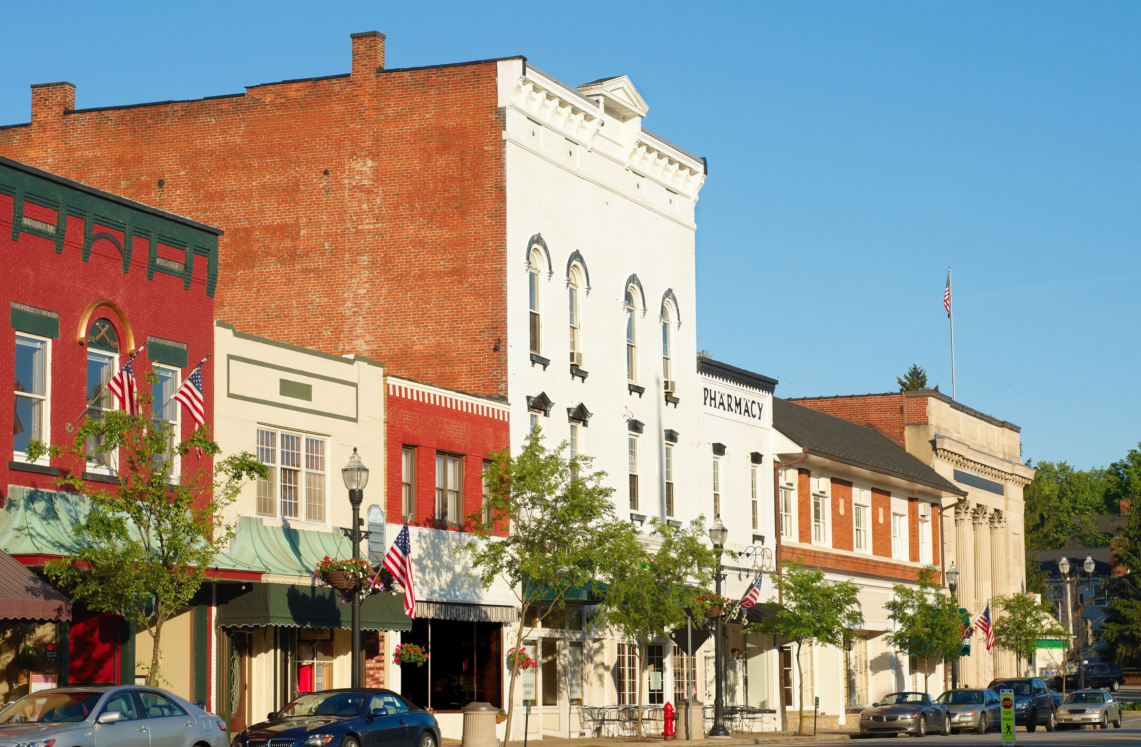 A historic downtown street with vintage buildings, including a pharmacy.