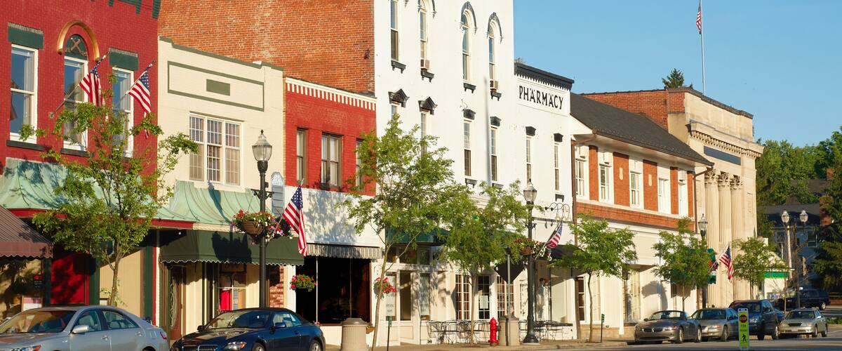 A historic downtown street with vintage buildings, including a pharmacy.