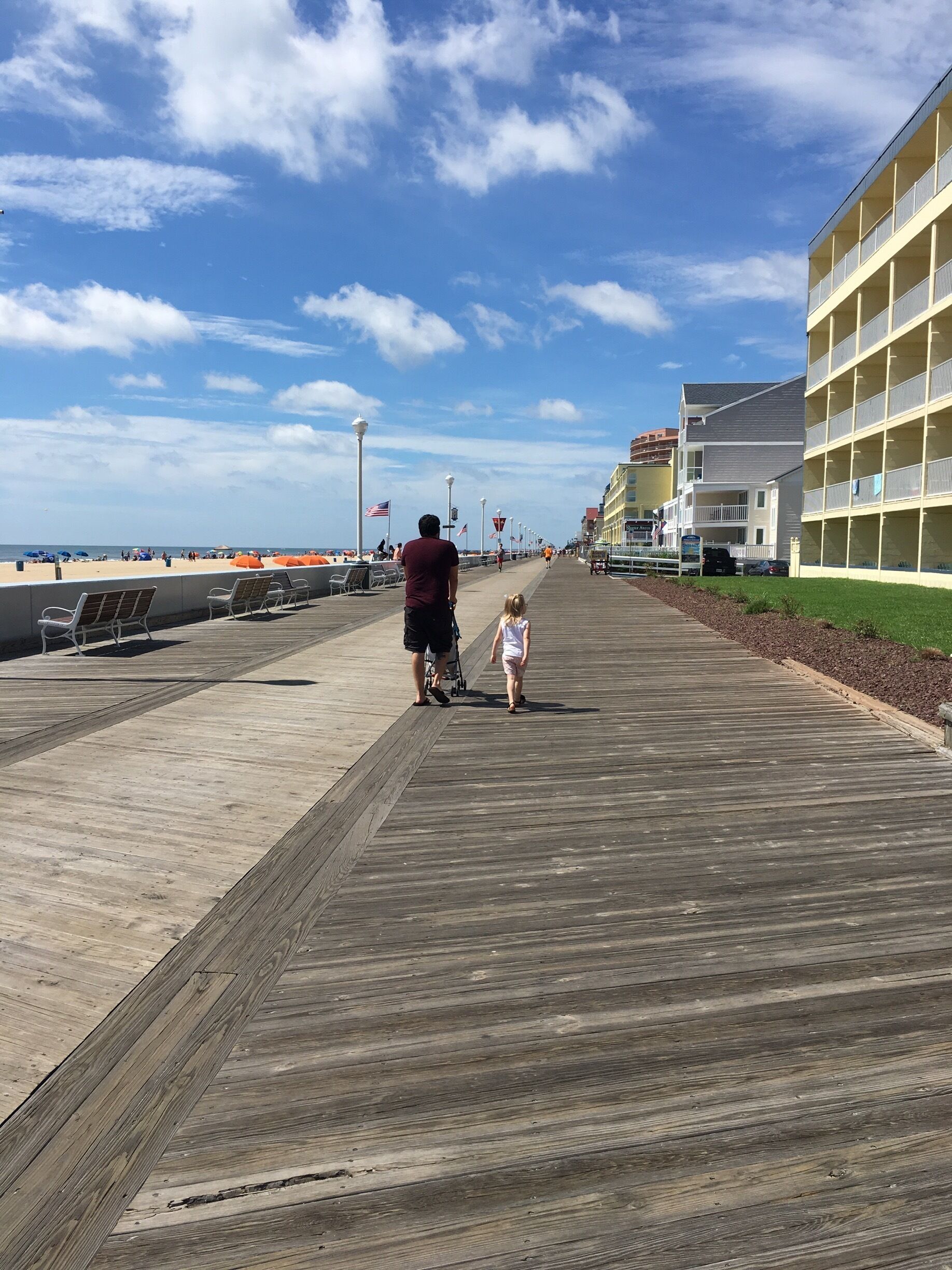 A wooden boardwalk with a person and a child walking away from the camera.