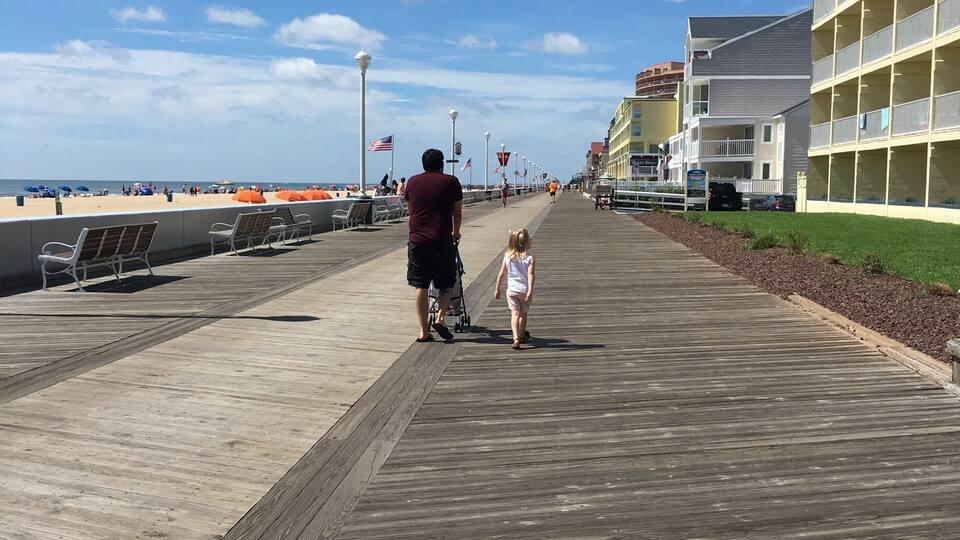 A wooden boardwalk with a person and a child walking away from the camera.