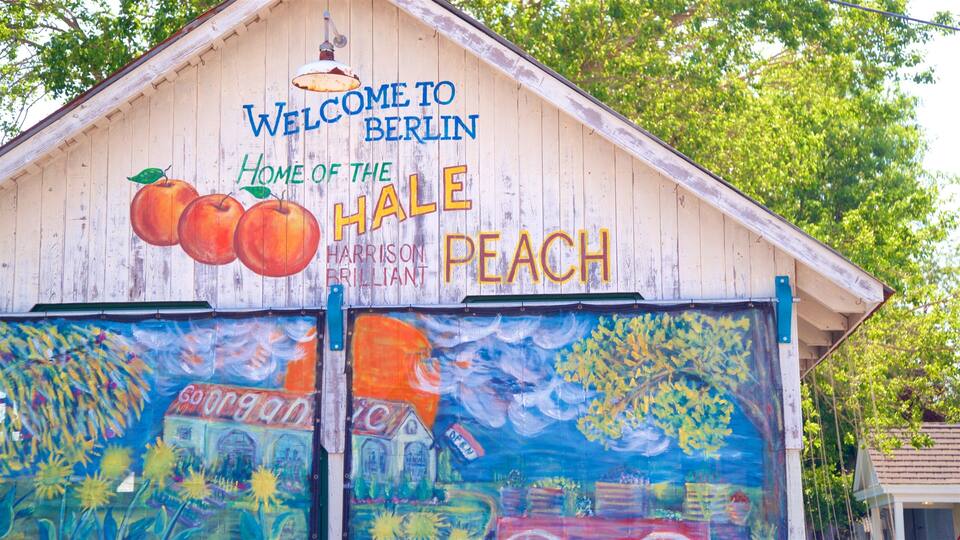 A wooden building with a sign that reads "Welcome to Berlin, Home of the Hale Peach."