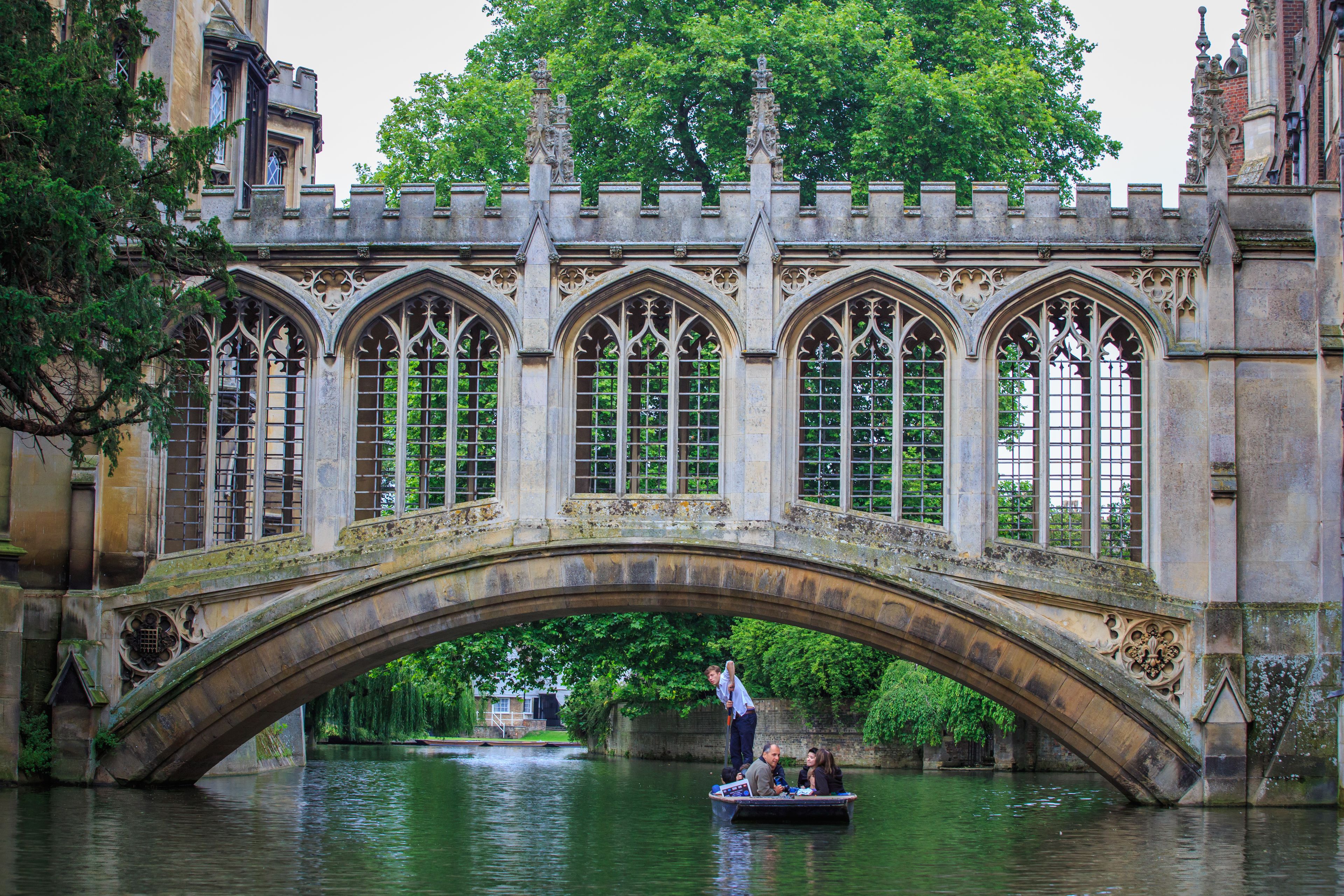 Un pont de pierre, doté d’arches en forme de fenêtres, et un bateau sur la rivière qui le traverse.