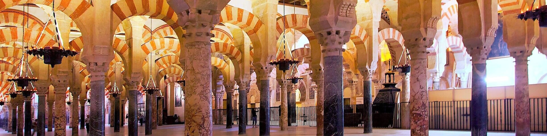 A grand hall with high arches and intricate ceiling designs.