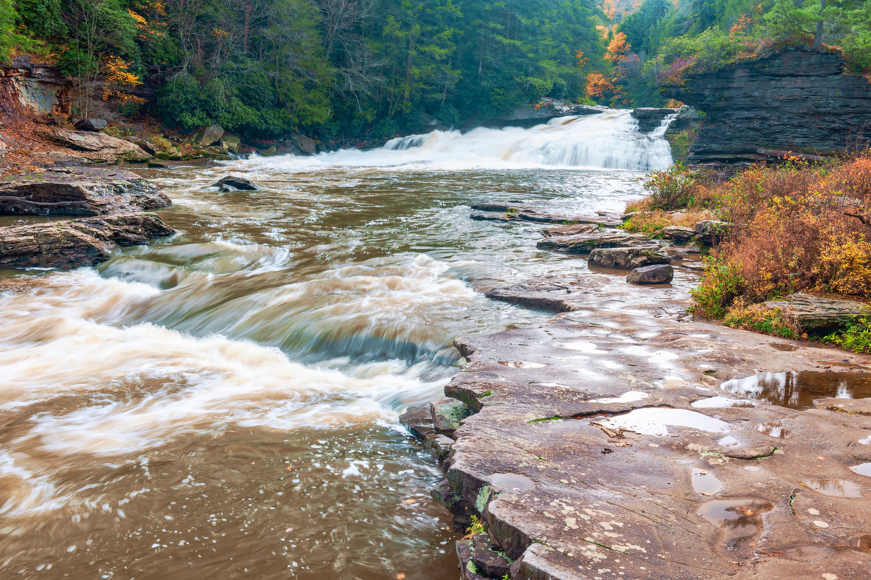 A river flowing through a rocky landscape with a waterfall.