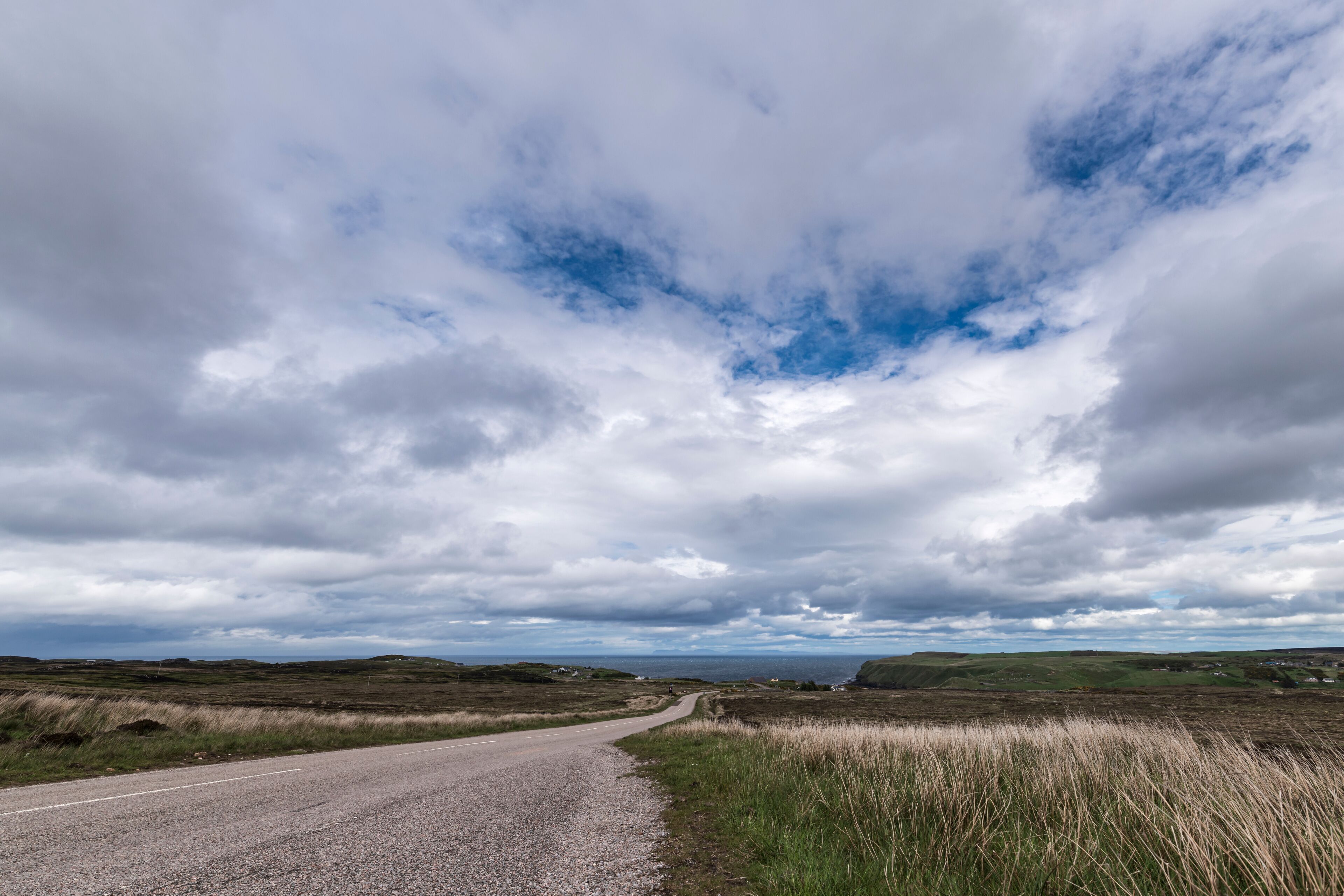 The A836 between Bettyhill and Strath, part of the North Coast 500 in Sutherland, Scotland. The Orkney Islanda are in the distance.