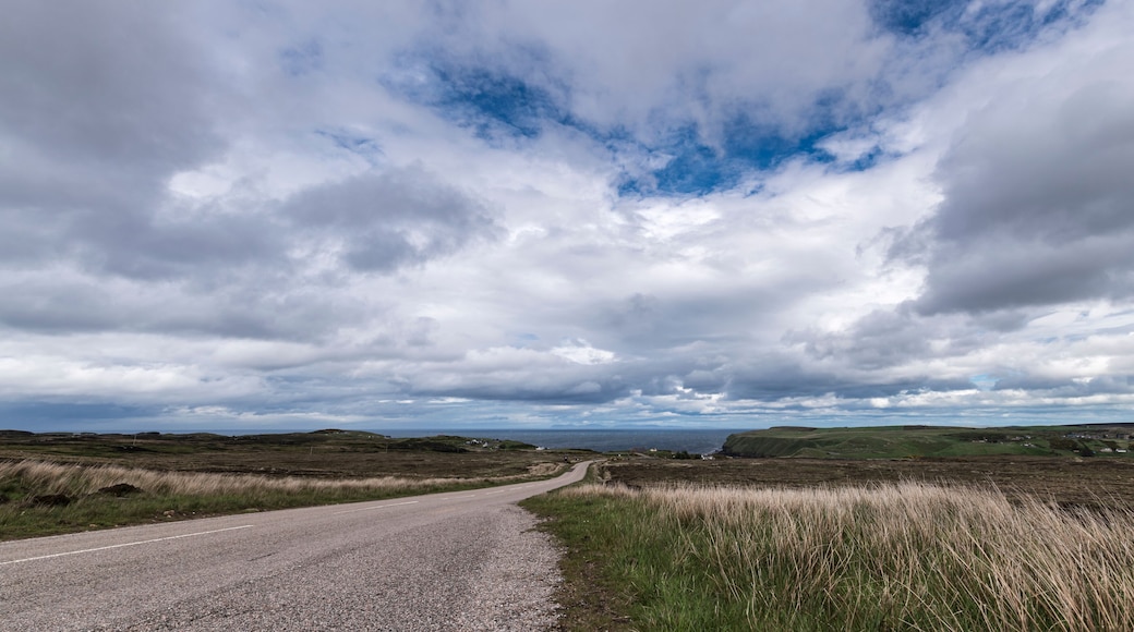 The A836 between Bettyhill and Strath, part of the North Coast 500 in Sutherland, Scotland. The Orkney Islanda are in the distance.