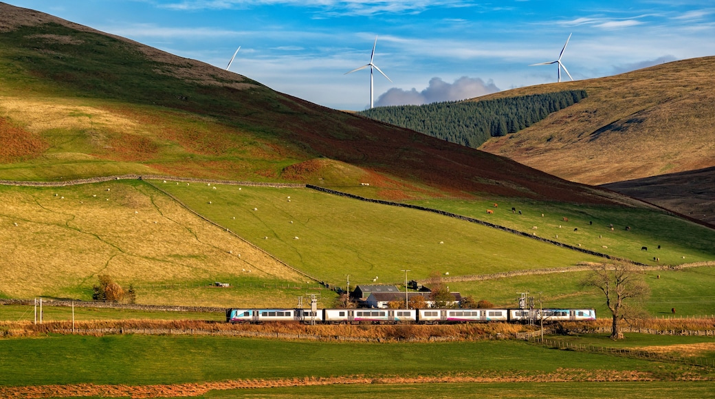 beautiful Landscape ,train A pair of Scotrail passenger trains climbon scottish highlands scenery of mountains and wind turbine on a summer's day