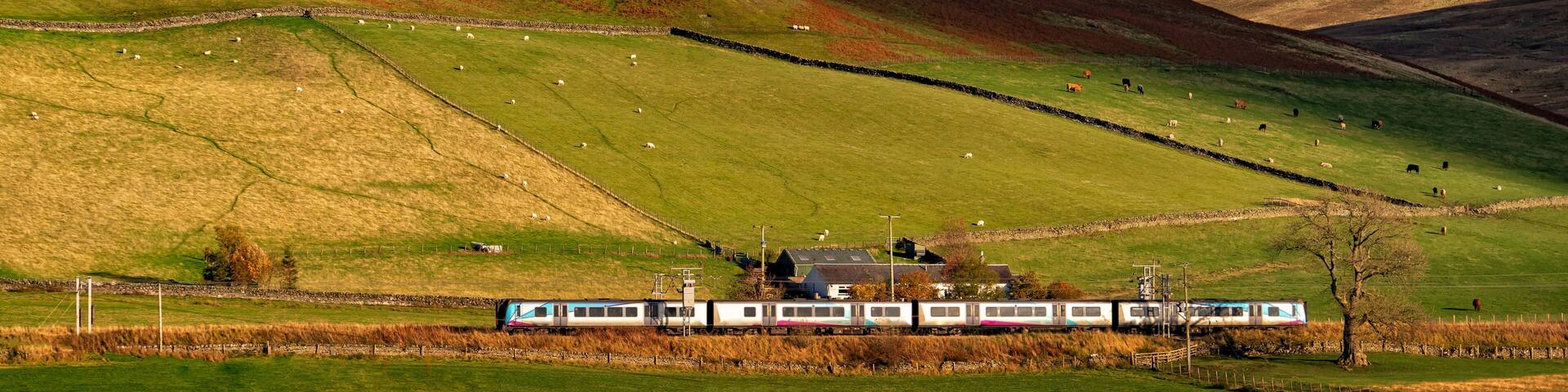 beautiful Landscape ,train A pair of Scotrail passenger trains climbon scottish highlands scenery of mountains and wind turbine on a summer's day