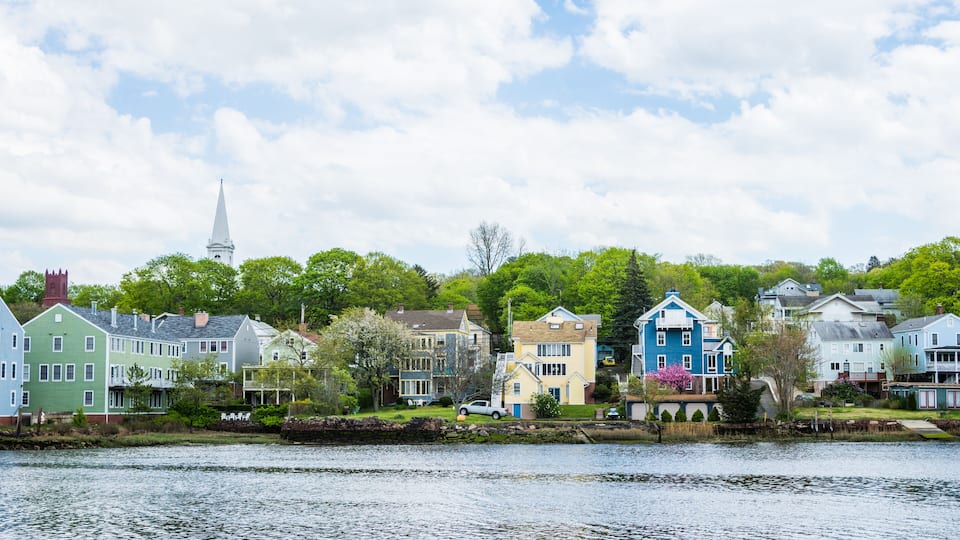A lakeside town with colorful houses and a church steeple.