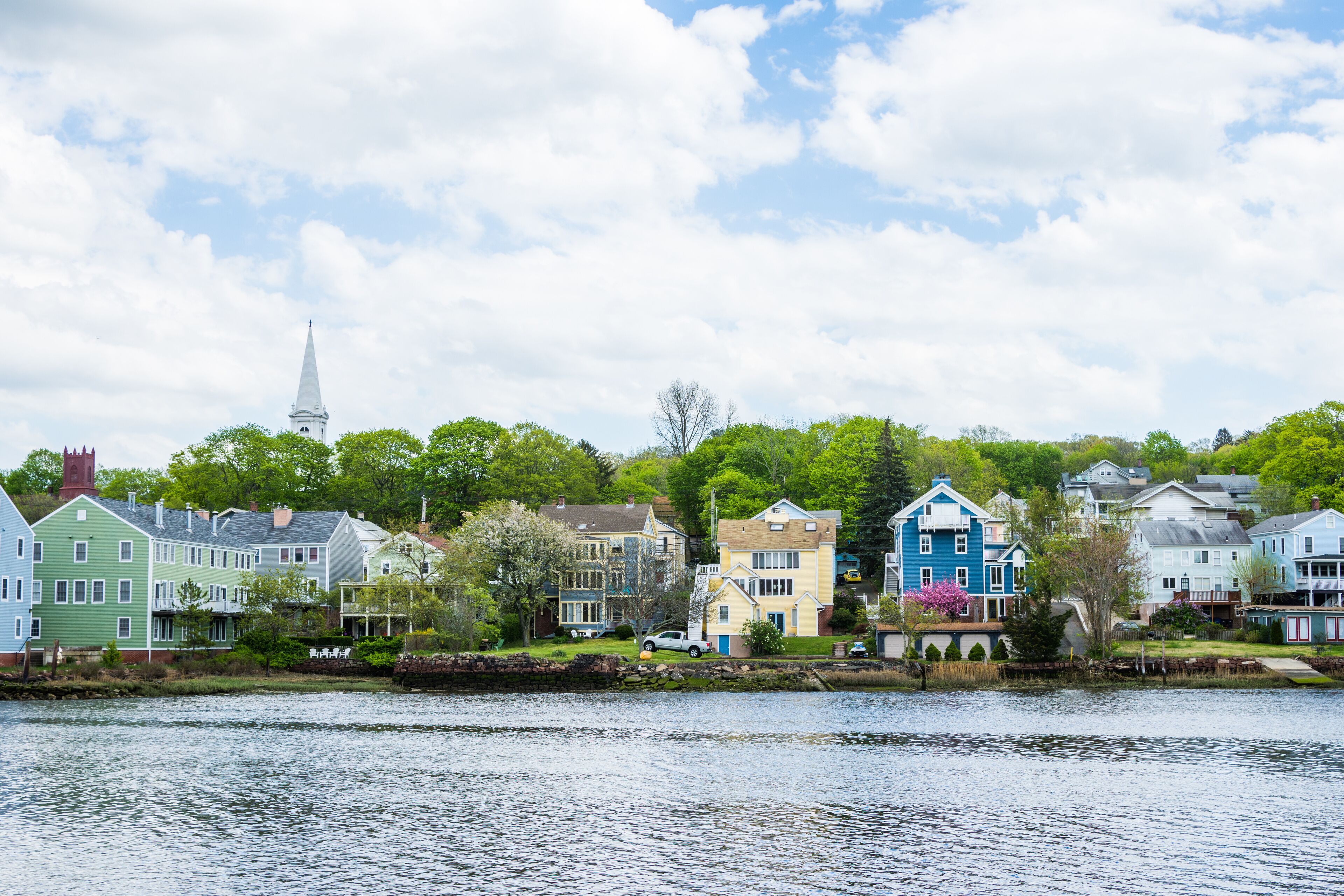 A lakeside town with colorful houses and a church steeple.