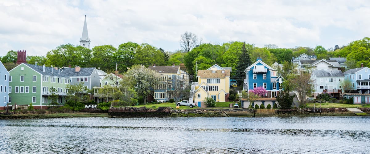 A lakeside town with colorful houses and a church steeple.