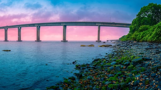 Dramatic beautiful stormy sunset panorama over Jamestown Verrazzano Bridge and Narragansett Bay in North Kingstown, Rhode Island, with a moored yacht in the rain.