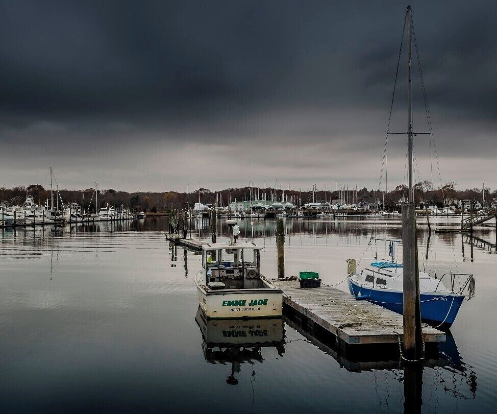 Took this photo in mid November. The boats were getting ready to be winterized. The air and sea were both very calm and in the distance, an approaching storm was coming. 