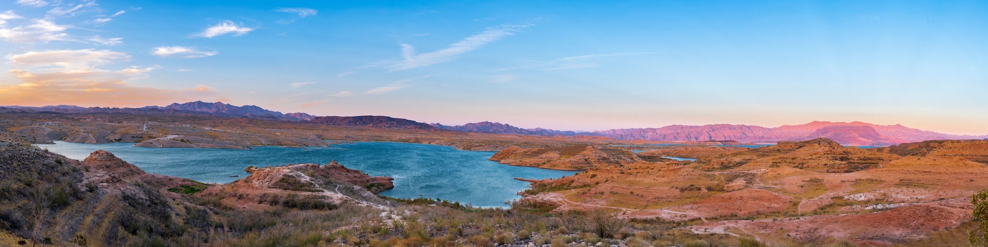 A mountainous landscape with a large body of water surrounded by rocky terrain and sparse vegetation.