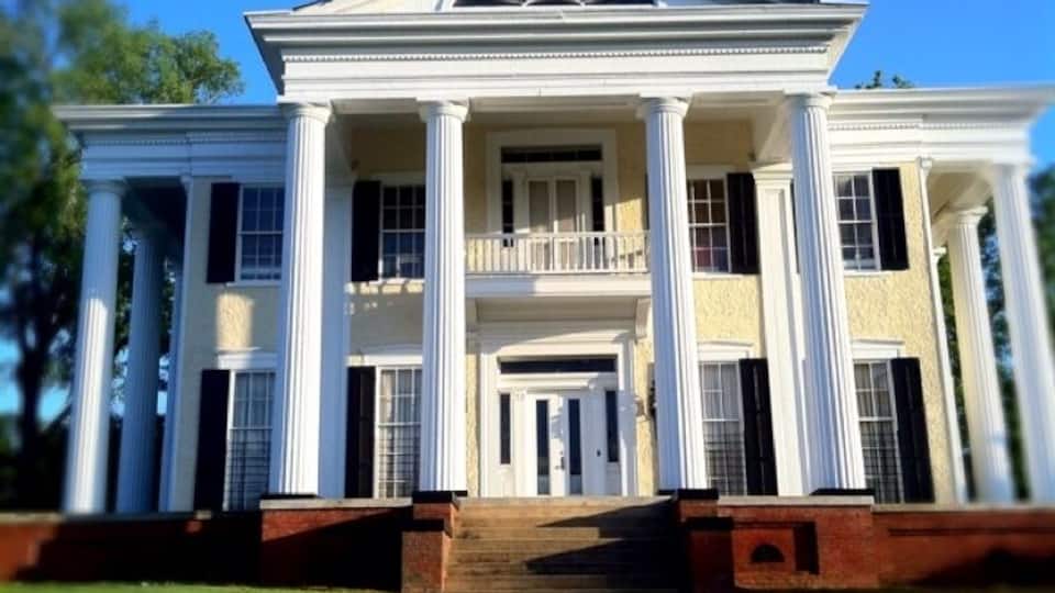 The Wynn House was built in 1839 when the city of Columbus was 11 years old. Greek Revival in style, the house has doric columns on three sides and is topped with a cupolo. Originally named “Oakview,” the house was built by Colonel William Wynn, for whom the Wynnton area of Columbus is named.
In 1852 Henry Hurt purchased the home from Colonel Wynn, but sold it in 1855 having never lived in it. The next owner, Mr. Hines Holt, was a prominent Georgia congressman and attorney. During the Civil War, his ownership saved the home from the Union Army captain sent to burn the homes in this area. The home remained in the Holt family for 50 years.
In 1905, Mr. J. T. (Tom) Cooper purchased the house and moved the structure closer to Wynnton Road so the land behind the house could be subdivided. Local legend supports that the house was moved a little too close to Wynnton Road when the mule team moving the house was left unattended at lunchtime!
In 1932 the house was bought and completely restored by Mr. and Mrs. S. C. Butler. The historic structure became the home of the CFA in 1958.