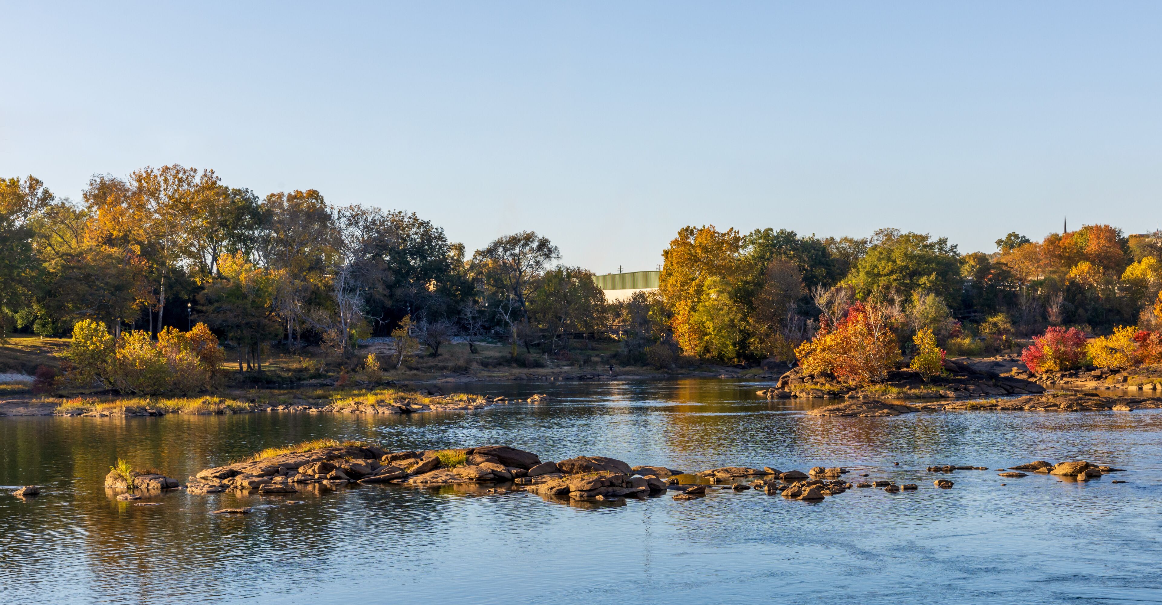 A river with rocks and trees with autumn foliage.