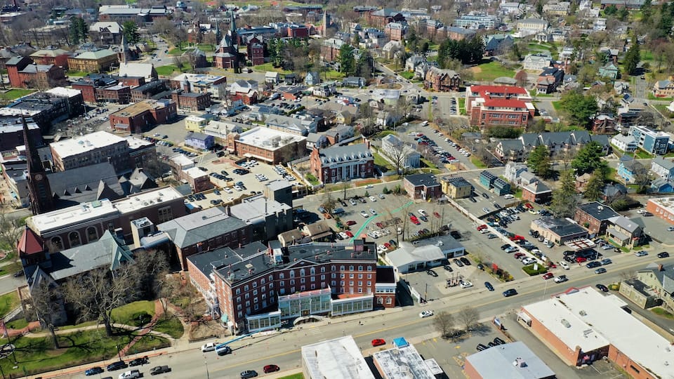 An aerial view of a town with historic buildings, a central square, and a mix of residential and commercial areas.