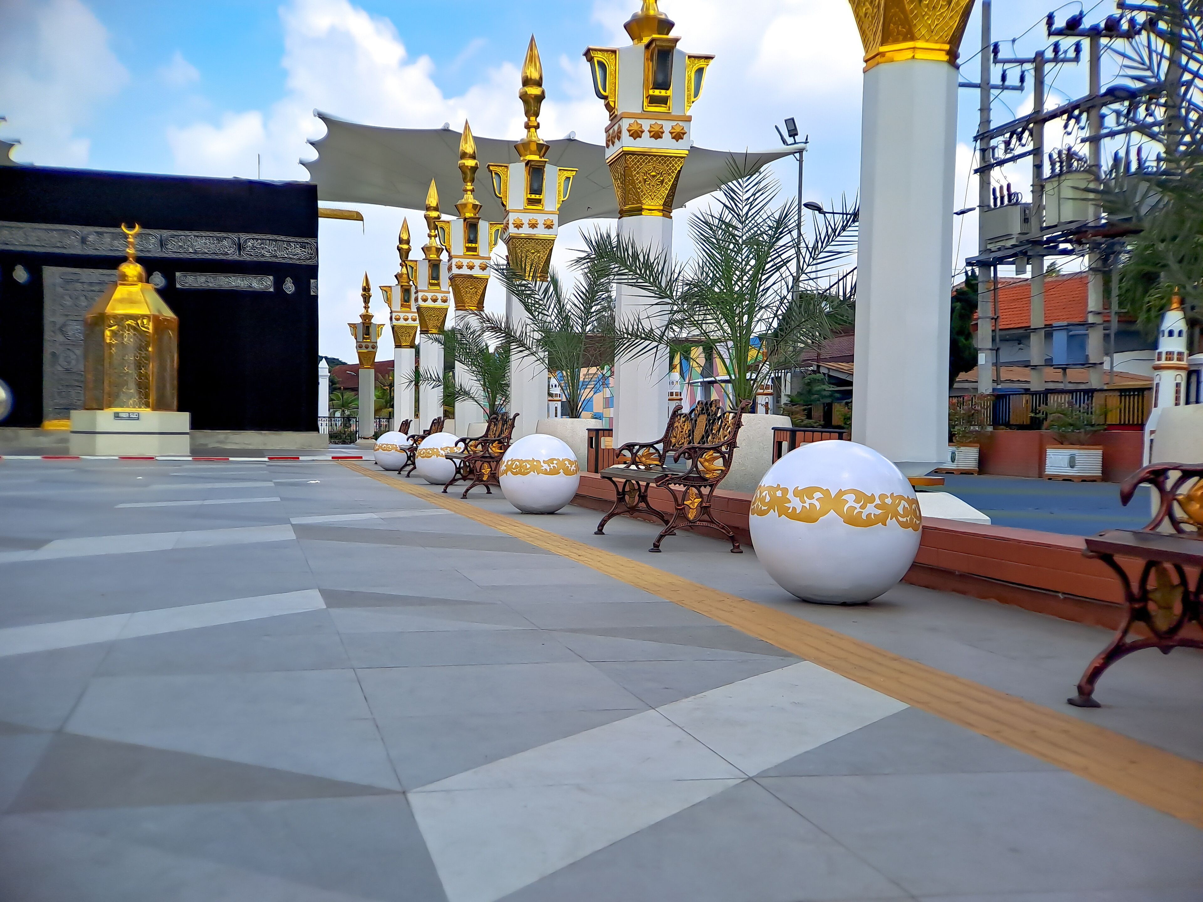 brown gold white color mosque minaret with arabic architecture in madiun indonesia park, sunny weather.