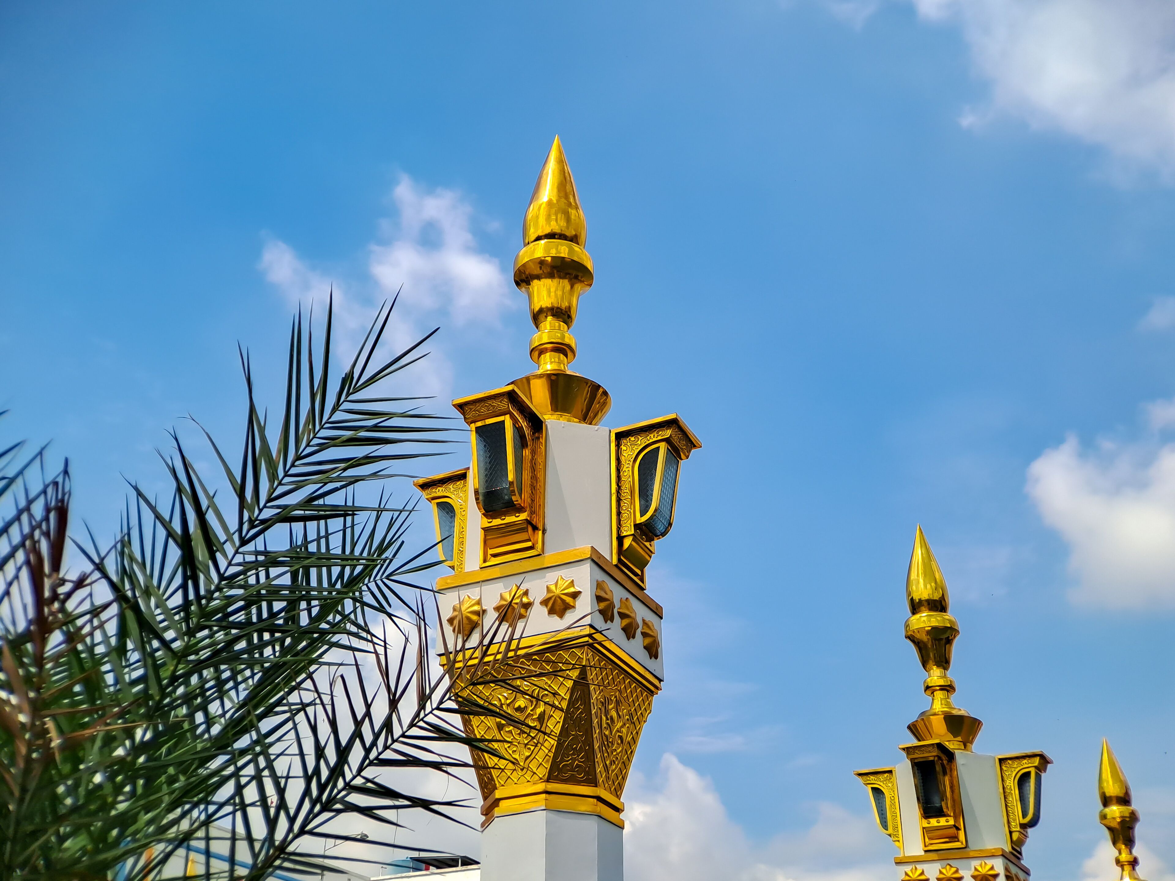 brown gold white color mosque minaret with arabic architecture in madiun indonesia park, sunny weather.